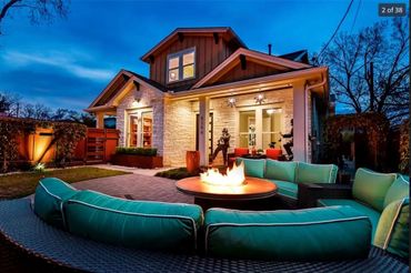 Cozy backyard fire pit with turquoise seating at dusk in a modern home.