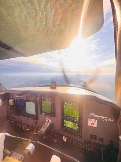 View from a Piper Aztec cockpit with sunlight streaming through the window.