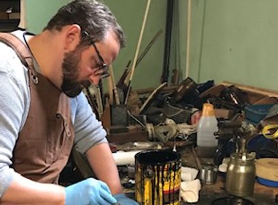 Employee repairing and staining furniture.