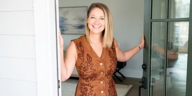 Smiling woman standing at a doorway.