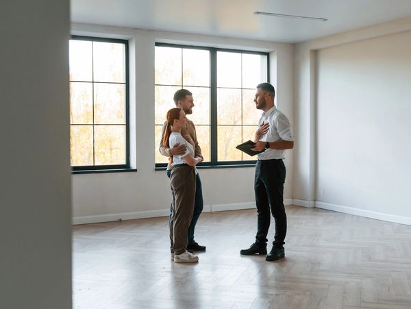 real estate agent shows an apartment to a young couple
