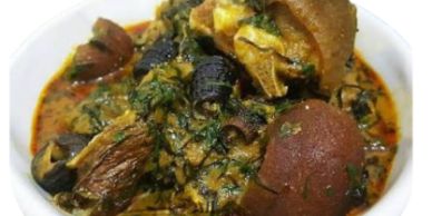 A bowl of Nigerian Egusi soup with assorted meats and vegetables.