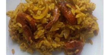 Plate of seasoned rice with cooked shrimp.