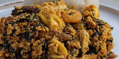 A close-up of a spicy Nigerian dish with assorted meats and vegetables.