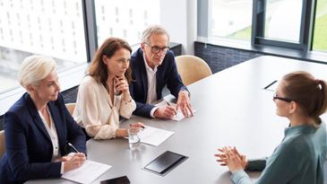 A professional interview with three interviewers and one candidate at a modern office.