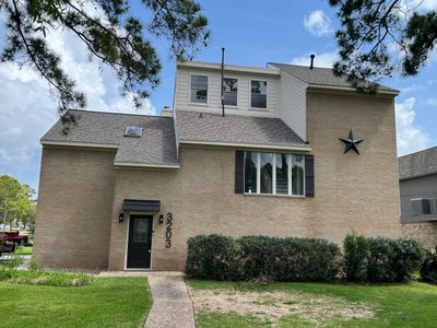 Modern two-story beige brick house with a large star decoration on the wall.