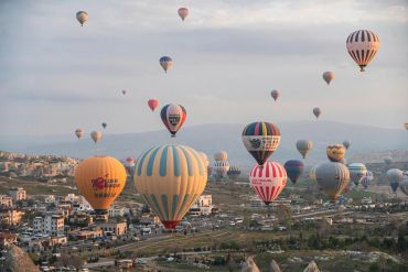 Hot air balloons flying over a town.