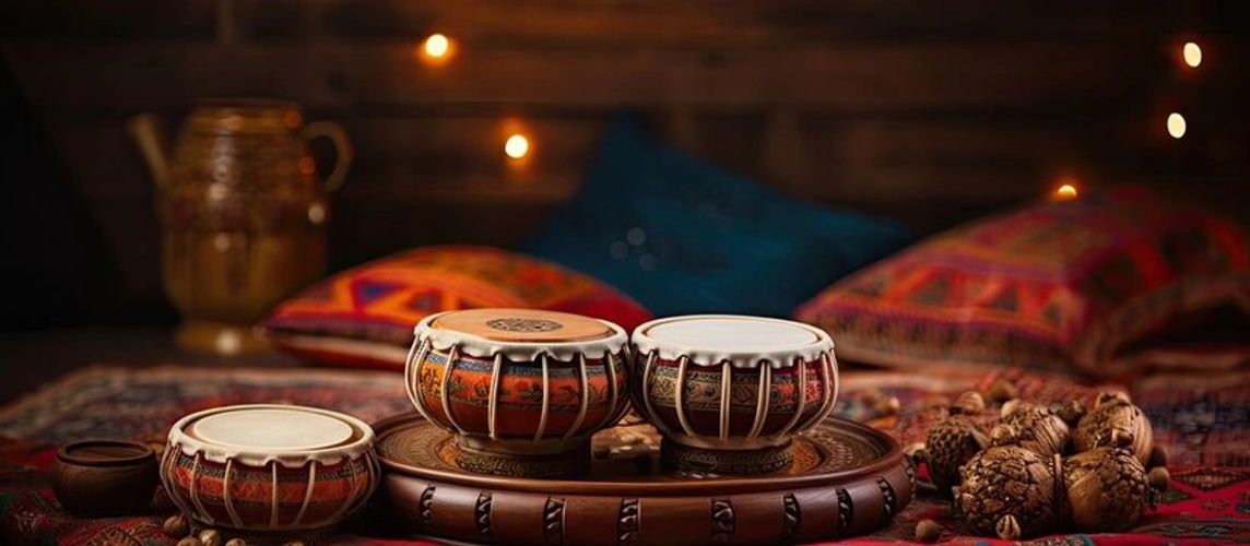 Traditional Indian tabla drums placed on a wooden tray with vibrant cushions in the background.