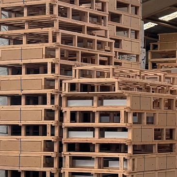Stacks of wooden pallets in a warehouse.