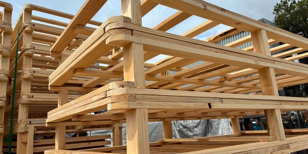 Stacked wooden frames or panels under construction outdoors.