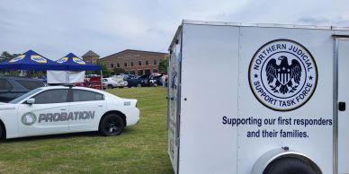 Probation vehicle and Northern Judicial Support Task Force trailer outdoors.