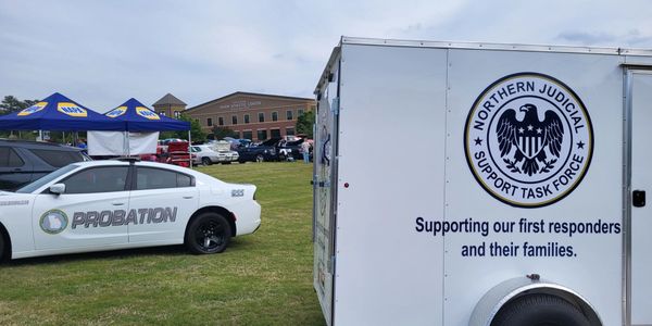 Probation vehicle and Northern Judicial Support Task Force trailer outdoors.