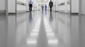 Hospital corridor with medical staff walking in the distance.