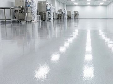 Cleanroom with reflective polished floor and workers in protective suits.