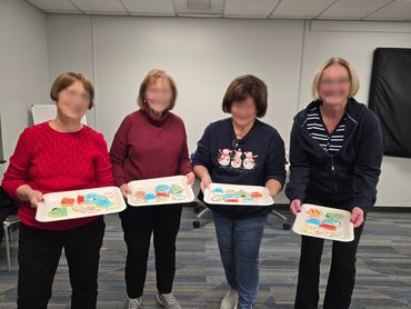4 women holding finished cookies