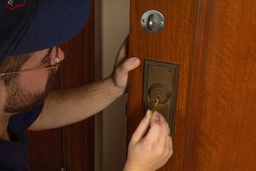 A photograph of myself in my Tom's Lock uniform inserting a key into the lock of door.