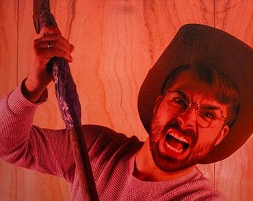 A red filtered photograph of myself in a cowboy hat swinging a rusty axe towards the viewer.