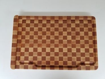 End grain cutting board in cherry and hard maple with juice groove and well