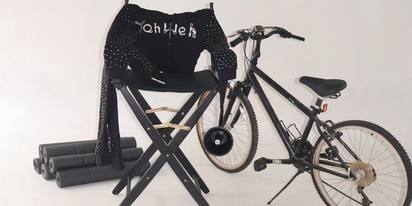 Black bicycle, chair, and clothing against white background.