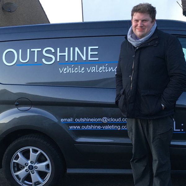 a smiling man next to the van
