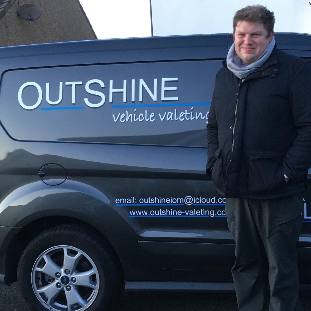 a smiling man next to the van