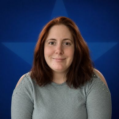 Woman with red hair smiling against a blue star background.