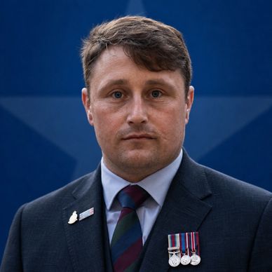 Man in suit with medals and pin.