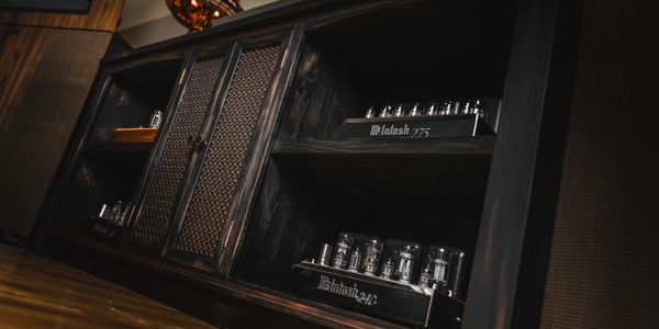 Vintage McIntosh audio amplifiers in a wooden cabinet.