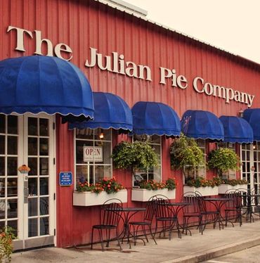 The Julian Pie Company storefront with blue awnings and outdoor seating.