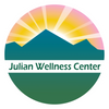 Logo of Julian Wellness Center with mountains and sunrise.