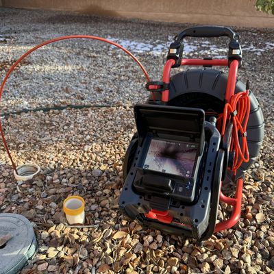 Inspection camera setup outdoors on gravel.