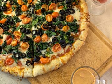 Pizza con tomate Cherry, espinacas y aceitunas