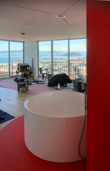 Modern apartment with a white circular bathtub and city view under renovation.