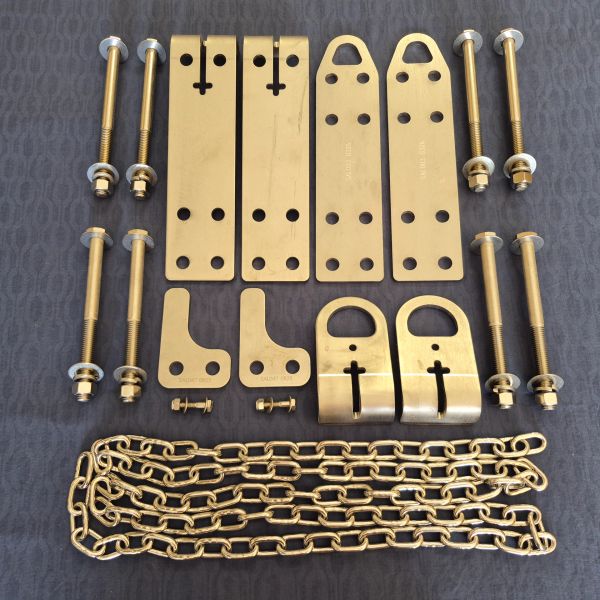 Brass hardware set including chains, bolts, and plates laid out on a surface.