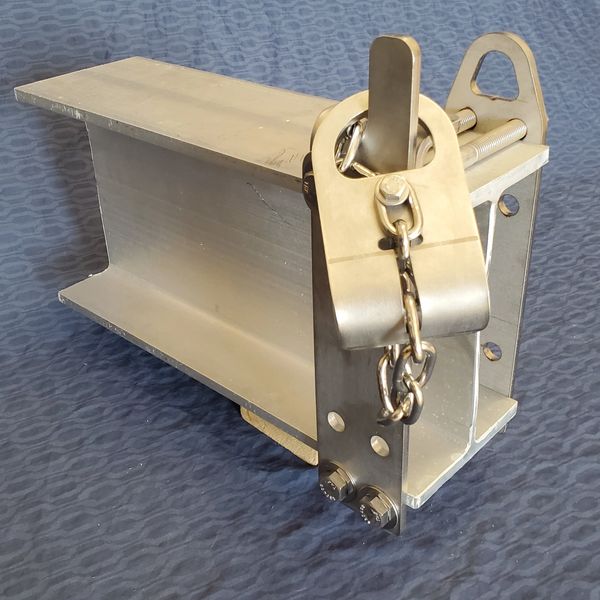 Metal industrial component with bolts and chain on blue fabric.