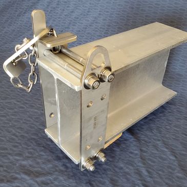Metal industrial component with bolts and a safety latch.
