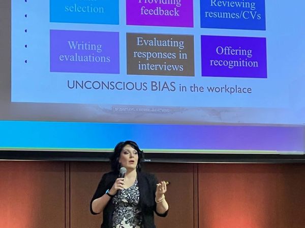 A woman giving a presentation on unconscious bias in the workplace.