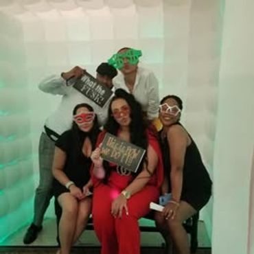Group of friends having fun with props in a photo booth.