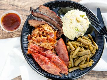 3 meat plate filled with green beans, potato salad, sausage, brisket and pulled pork.