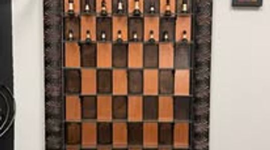 Decorative wooden chessboard wall art with chess pieces.