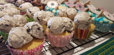 Cupcakes topped with cookies and cream frosting and decorated with colorful wrappers.