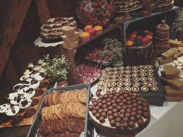 A rustic dessert table filled with assorted cookies, cupcakes, and chocolates.