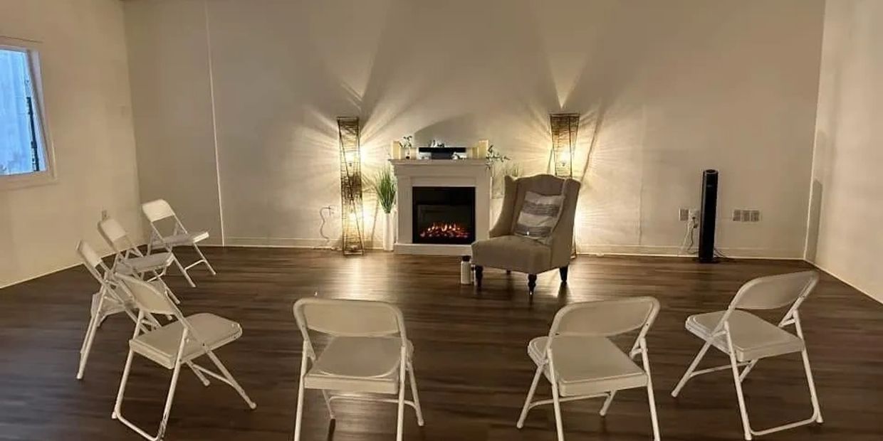 Circle of chairs in a cozy, minimalistic room with fireplace.