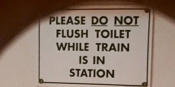 Sign that says: Please do not flush while in train station. 
