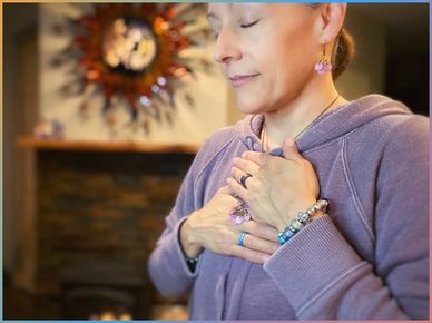 Maria-Lupita Gurule has her eyes closed with her hand over her heart.