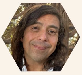 Rafael Garcia is smiling standing by a tree.