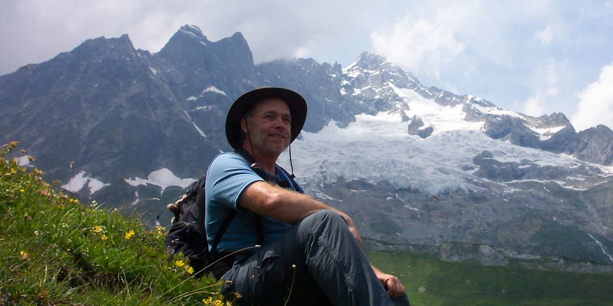Brian resting in a field of alpine wild flowers while hiking around Mt. Blanc, 2004.