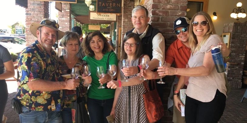 A group of attendees raise their wine glasses