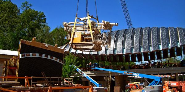 A crane lowering FS GEOCON Beretta T41 rock drill into place during construction of Crystal Bridges.