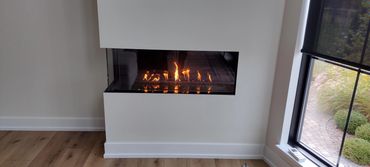 a gas fireplace insert installed on the corner of a wall